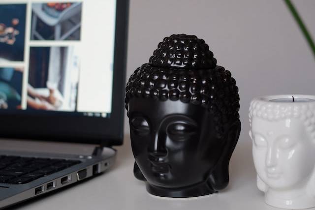 computer and buddha statuettes